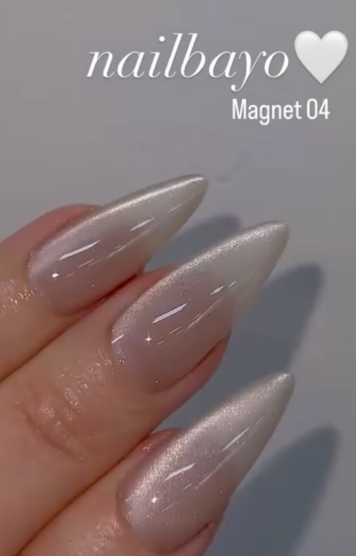 Nailbayo DOI Magnet Gel # 4 - 10ml, a Korean nail supply product by the renowned artist NAILBAYO, featuring a captivating magnetic design, perfect for creating unique and eye-catching nail art. This gel requires a specialized magnet tool for application, allowing users to explore the exciting possibilities of magnetic nail polish. The image showcases the product's sleek, silver-toned packaging and the intricate nail patterns achievable with this