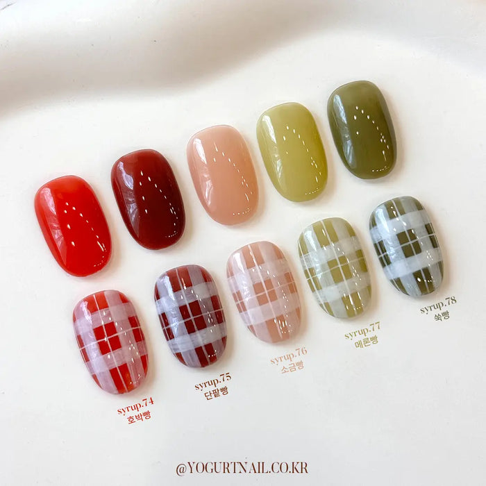 Vibrant autumn-inspired gel nail colors in a collection, showcasing a variety of warm, earthy tones mimicking the hues of freshly baked bread and melting syrup. The diverse selection offers a range of shades, from rich reds to soft peach and olive green, providing a cozy and inviting visual representation of the "YOGURT Ginger Bread Collection.