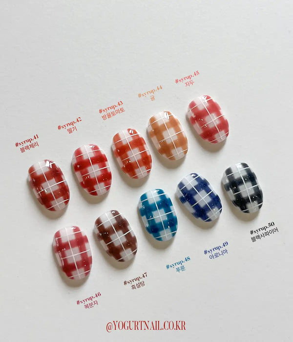 The image depicts a collection of nail gel products in various deep, self-leveling syrup shades inspired by the candied fruit, Tanghulu. The product is called the "YOGURT Tanghulu Collection" and comes in 10 different color options, which are shown in the image. The nail gels are encased in 8ml bottles and require a 60-second UV/LED curing time.