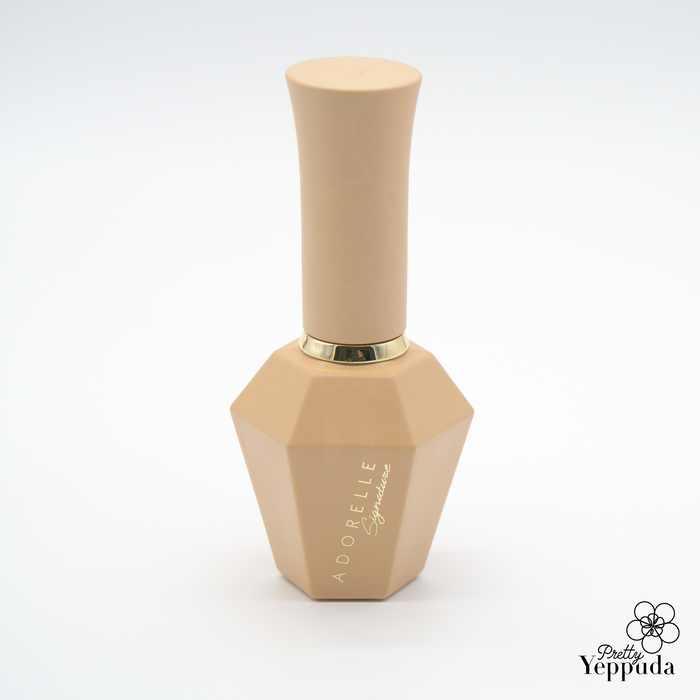 Elegant beige nail polish bottle from ADORELLE Romantic Vintage collection, featuring a unique hexagonal base and sleek cylindrical cap. The bottle showcases a refined design with gold lettering, embodying sophistication and timeless charm. Perfect for achieving a classic, romantic manicure look.