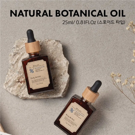 A bottle of Bevlah's Natural Botanical Oil with a dropper cap sits on a textured beige background, surrounded by delicate white flowers. The oil promises to soothe rough skin and keep it moisturized with 96% natural oils, suitable for use on the face, body, and hair. This multi-purpose botanical oil is certified vegan and cruelty-free.