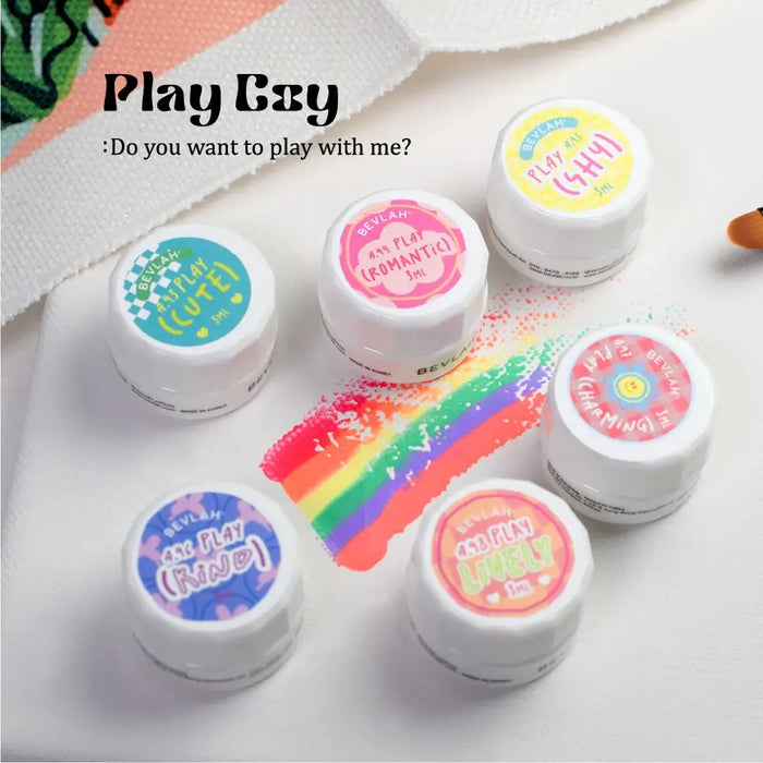 Colorful nail polish bottles with playful labels, showcasing the Bevlah Playcoy brand's variety of scent-free, HEMA-free, and 13-free vegan nail gel formulas.