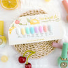 A display of eight pastel nail colors from the Smoothie Fresh Pastel Tone Collection by BY MUSE, arranged on a card with a lemon and floral design. The colors range from BS 41 White Sand to BS 48 Shape Gray, with nail polish bottles and cherries decorating the scene for a fresh, summery feel.