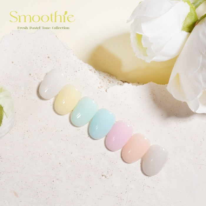 Swatches of the BY MUSE Smoothie Fresh Pastel Tone Collection arranged in a row on a textured surface. The pastel shades shown from left to right include BS 41 White Sand, BS 42 Forsythia, BS 43 Surf Crest, BS 44 Powder Blue, BS 45 Light Lavender, BS 46 Pink Lace, BS 47 Tuft Blush, and BS 48 Shape Gray. White floral decorations are placed nearby.