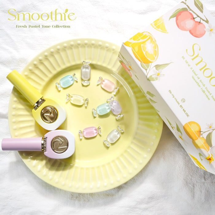 Smoothie Fresh Pastel Tone Collection, featuring two nail polish bottles (yellow and lavender) on a yellow plate with pastel-colored candy pieces and the product packaging box in the background, decorated with fruit illustrations.