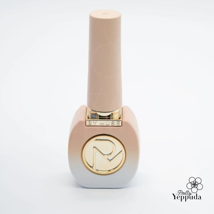 Detailed alt text for the "BY MUSE 40 pcs" Shopify product image: A close-up, high-quality image of a peach-colored nail polish bottle with the "BY MUSE" logo prominently displayed. The bottle has a rectangular shape with a tall, cylindrical cap on top. The gold-colored brand logo adds a touch of elegance to the design. This product is part of the "Be My Muse 40pc syrup gel collection" and includes 32 syrup gels and 8 tinted syrups that are HEMA-