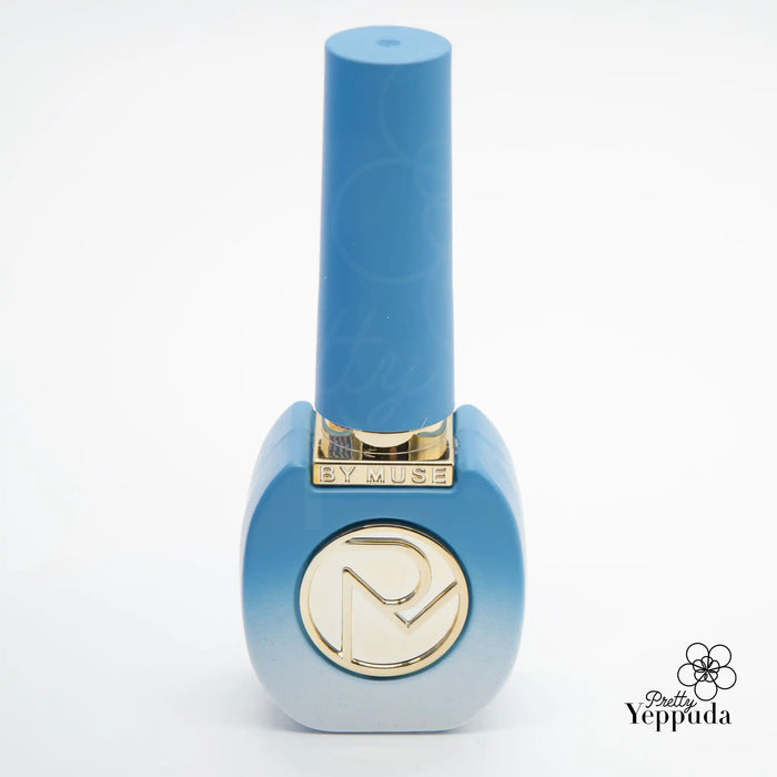 Enchanting By Muse nail polish bottle in a captivating blue hue, embodying the magical essence of the Fairy Tale collection. The sleek, elegant design and gold-toned logo evoke a sense of whimsy and sophistication, perfect for those seeking to add a touch of enchantment to their beauty routine.  brand, nail polish, beauty