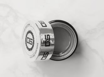 Open jar of DGEL painting gel in silver, displayed on a marble surface. The jar lid, branded with DGEL logo, rests beside the silver gel.