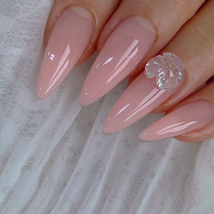 This image showcases a set of elegant, light pink nail designs featuring Nailbayo DOI Aube #03 - a 10ml colored builder gel product from the renowned Korean nail artist Nailbayo. The gel overlay application results in a sleek, glossy finish, accentuated by a single, eye-catching crystal accent nail. This nail art exemplifies the high-quality, HEMA-free Korean nail supplies available through the Nailbayo brand.