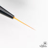 A close-up shot of a black JELLO JELLO Flexible Brush, its supple bristles gently curving as they release a vibrant orange paint, showcasing the dynamic versatility and expressive capabilities of this premium art supply from the JELLO JELLO brand.