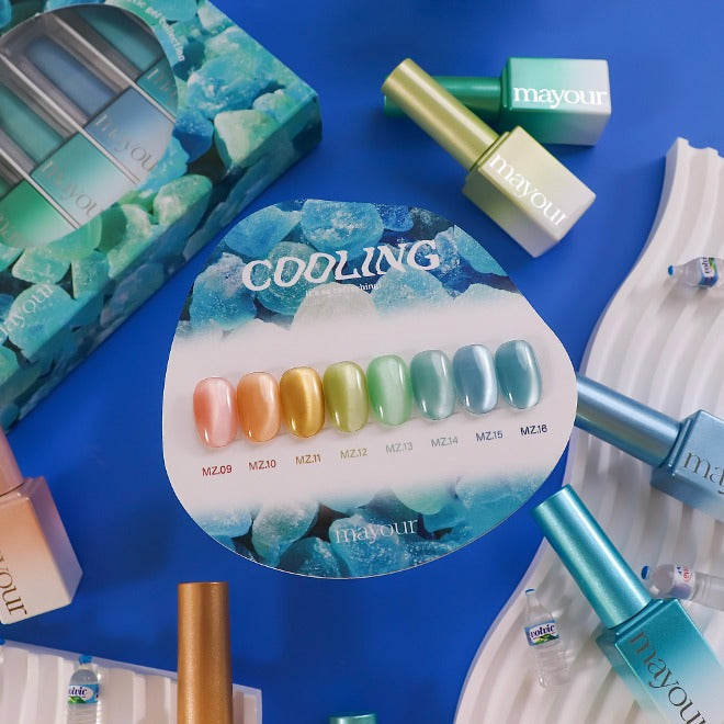 The image shows a display of the MAYOUR Cooling Collection, a set of 8 magnetic gel polishes in cool, icy hues. The nail polish bottles and a swatch card showcasing the diverse range of colors are prominently featured against a vibrant blue background, creating an eye-catching and visually appealing composition.