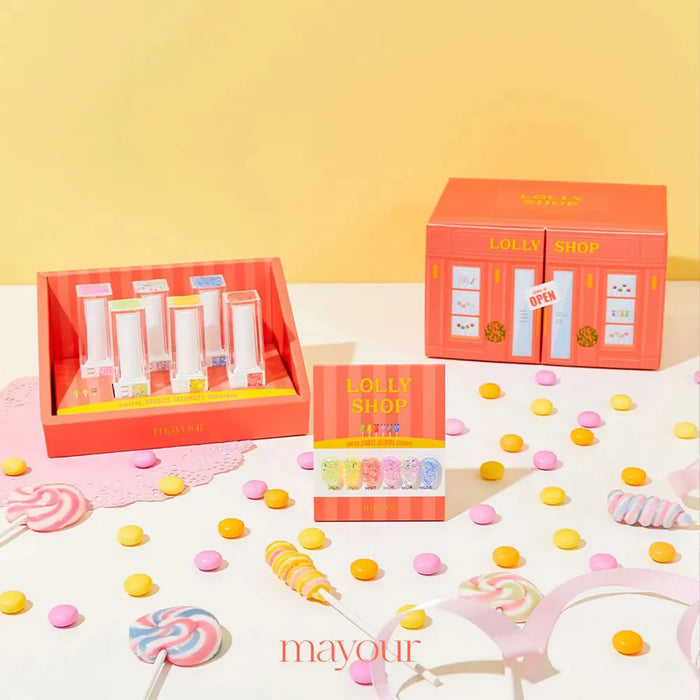 A vibrant and whimsical collection of sugary treats, including iridescent gels and hexagon glitters in various colors, presented in a playful Lolly Shop display with a bright and inviting aesthetic. The product promises to satisfy every sweet tooth, allowing for versatile application from layering to creating ombre effects. The MAYOUR brand shines through with its emphasis on indulgence and creativity.