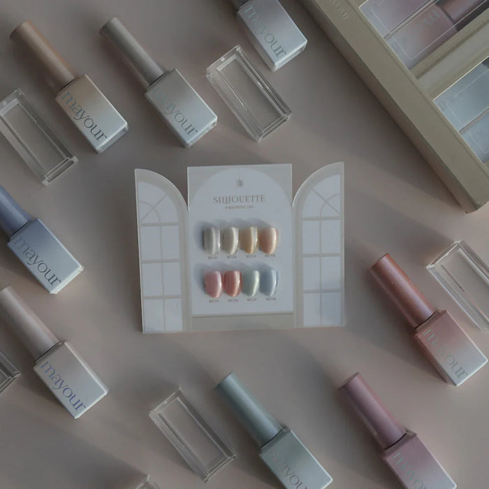 An array of nail polish bottles and samples from the MAYOUR Silhouette Collection, showcasing the diverse range of shimmering, dewy shades available in this 8-piece set. The vibrant and captivating nail polish colors are prominently displayed, inviting customers to explore and enhance their nail artistry with this premium, magnetic gel formulation.