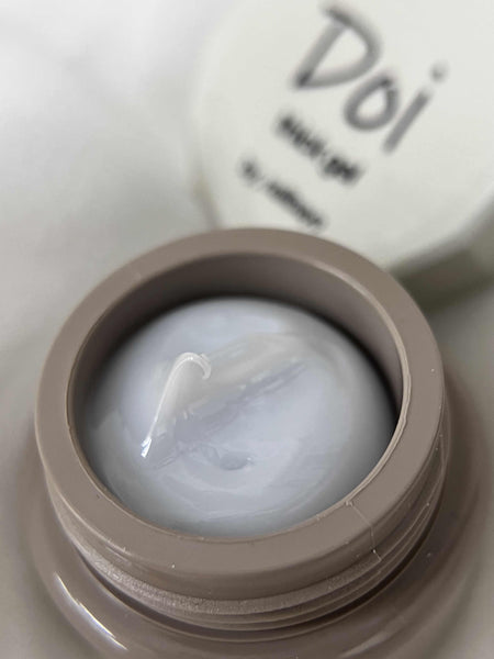 Close-up of Nailbayo DOI Thick Gel container, showcasing the product's luxurious texture and high-quality appearance. The gel's smooth, creamy consistency is visible in the open jar, with the brand name "Doi" prominently displayed on the lid, highlighting its Korean nail art heritage and professional-grade formula.