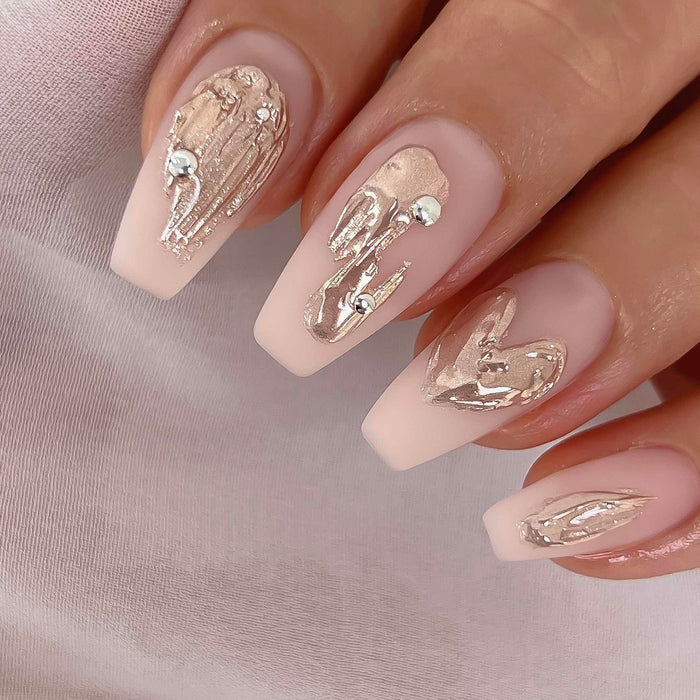 Elegant manicure featuring long coffin-shaped nails with a soft pink base and intricate metallic gold foil accents, showcasing the luxurious finish and artistic potential of Nailbayo DOI Thick Gel. The nail art demonstrates the gel's versatility for creating sophisticated, high-end designs with a Korean-inspired aesthetic.