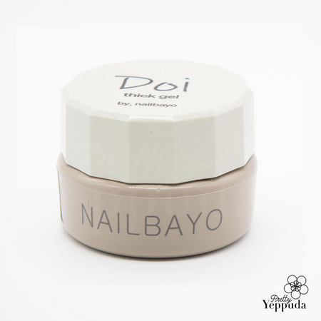 Elegant jar of NAILBAYO Tong Thick Gel, featuring a white octagonal lid with 'Doi thick gel' inscription. The cream-colored base displays the brand name 'NAILBAYO' in sleek, gray lettering. Premium nail care product for professional-quality manicures and nail art applications.