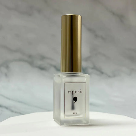 Elaborative alt text for the RIPOSO Ink Blender (8g) product image: A sleek, minimalist glass bottle with a gold-colored cap sits atop a white surface against a marble background. The bottle is labeled "RIPOSO Ink" in a simple, elegant font, showcasing the essential tool for creating captivating marble or stone-like art effects using high-quality ink from any brand. The 8g volume capacity ensures ample product for all your artistic endeavors, mak