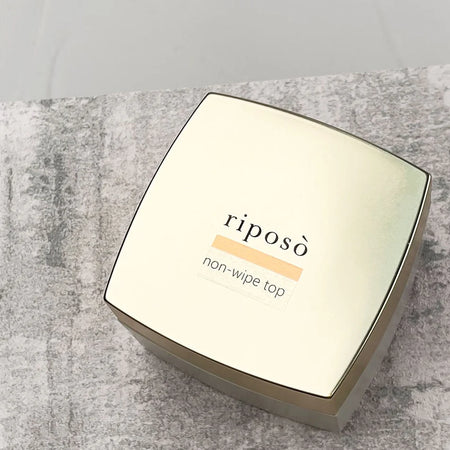 The image shows a powder-specific gel product by the brand Riposo, called the "RIPOSO Non-Wipe Top Gel". The product is designed to enhance the quality and longevity of powder nails, providing a smooth, flawless finish without chipping or dullness. The product is available in two sizes, 10g and 30g, and requires curing under UV or LED light for 30-60 seconds.