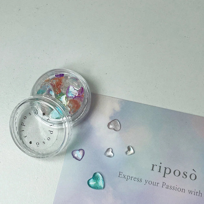 Five transparent and colorful nail gel containers labeled as the Riposo Pulling Layered Collection, including a heart charm, displayed on a light background with the brand name "riposo" and the tagline "Express your Passion with".