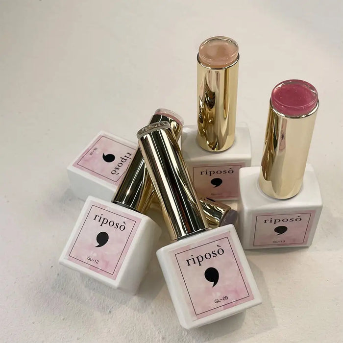 The image shows several products from the Riposo Veil Glinting collection, including syrup glitters and lipstick-like containers. The products feature a mix of subtle gold glitters and colors, conveying a classy and delicate feel. The glitters are described as fine, smooth, and premium, providing a soft application without the stiffness of chunky round gold glitters. The image showcases the variety and quality of the Veil Glinting products, highl