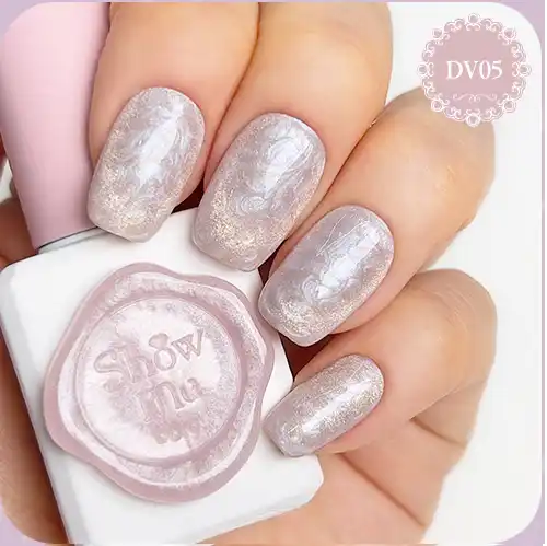 A close-up image showing a person's hands with pale pink nails that have a shimmery, pearlescent finish and a swirling, threaded pattern created using a magnetic cateye gel polish. The product name "SHOW ME KOREA - Deja Vu Pearl/Cateye Series" is prominently displayed on the product packaging.