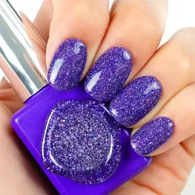 Sparkling purple nail polish bottle and painted nails showcasing the vibrant, glittery Kitsch Collection by Show Me Korea. The gels in this collection are designed to dazzle and captivate with a firework-like sparkle effect when illuminated by a flash of light, creating a must-have item for any nail polish enthusiast. Shopify, Korea, Kitsch.