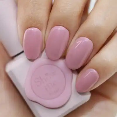 A close-up image of a hand displaying a pink nail polish from the SHOW ME KOREA Yeori Yeori Collection, which features a syrup-like translucent consistency and a subtle pearlescent finish. The nail polish bottle is visible, showcasing the brand's sophisticated and high-quality nail care products.