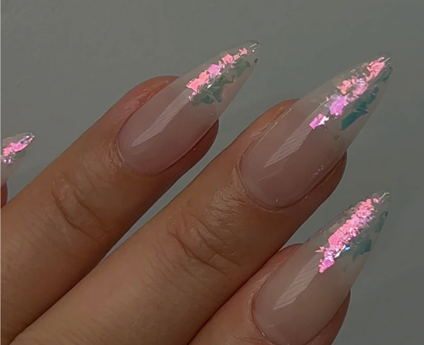 Iridescent pink glitter adorns the nude nails, creating an eye-catching, aurora-inspired look perfect for Nailbayo's Shopify product, "Pink Sunset Glitter". The captivating design complements the brand's focus on high-quality nail products that elevate natural beauty and artistic expression.