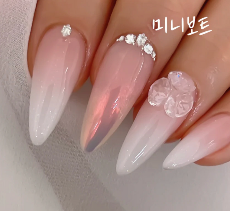 A delicately crafted, pearly pink nail set featuring intricate floral designs, showcasing the refined and luxurious Nailbayo brand aesthetic.