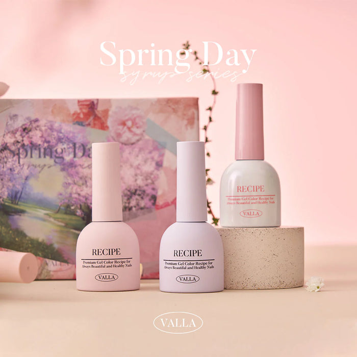 Elegant spring-themed display showcasing the VALLA Spring Day Collection, featuring a variety of pastel-colored gel nail polishes and a glitter gel, set against a soft, floral backdrop. The vibrant and warm colors evoke the feeling of the new spring season.