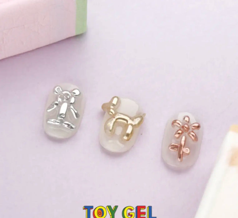 Delicate 3D clear clay gel charms in various whimsical shapes - a diver, a butterfly, and a flower. The VALLA Toy Gel product can be rolled, squished, and sculpted for fun 3D nail art decorations. The gel retains some elasticity when fully cured, making it suitable for detailed 3D nail designs while avoiding cracks in the top coat.