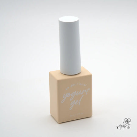 Elaborative Alt Text: A minimalist image showing a white cylindrical bottle with a light beige packaging on the base. The packaging features the Yeppuda brand name in a handwritten style font, indicating this is a premium cosmetic or skincare product. The simple, clean design and monochromatic color scheme suggest a high-quality, modern, and sophisticated Yeppuda product.