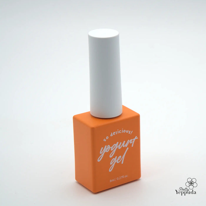 A bright and vibrant orange bottle with a white cap sits prominently in the center of the image. The bottle features the text "Yogurt Gel" in cursive lettering, conveying a delicious and indulgent product. The simple, minimalist design of the bottle allows the bold color to take center stage, creating an eye-catching and appealing visual for the "YOGURT Grocery set 90 colors" Shopify product.