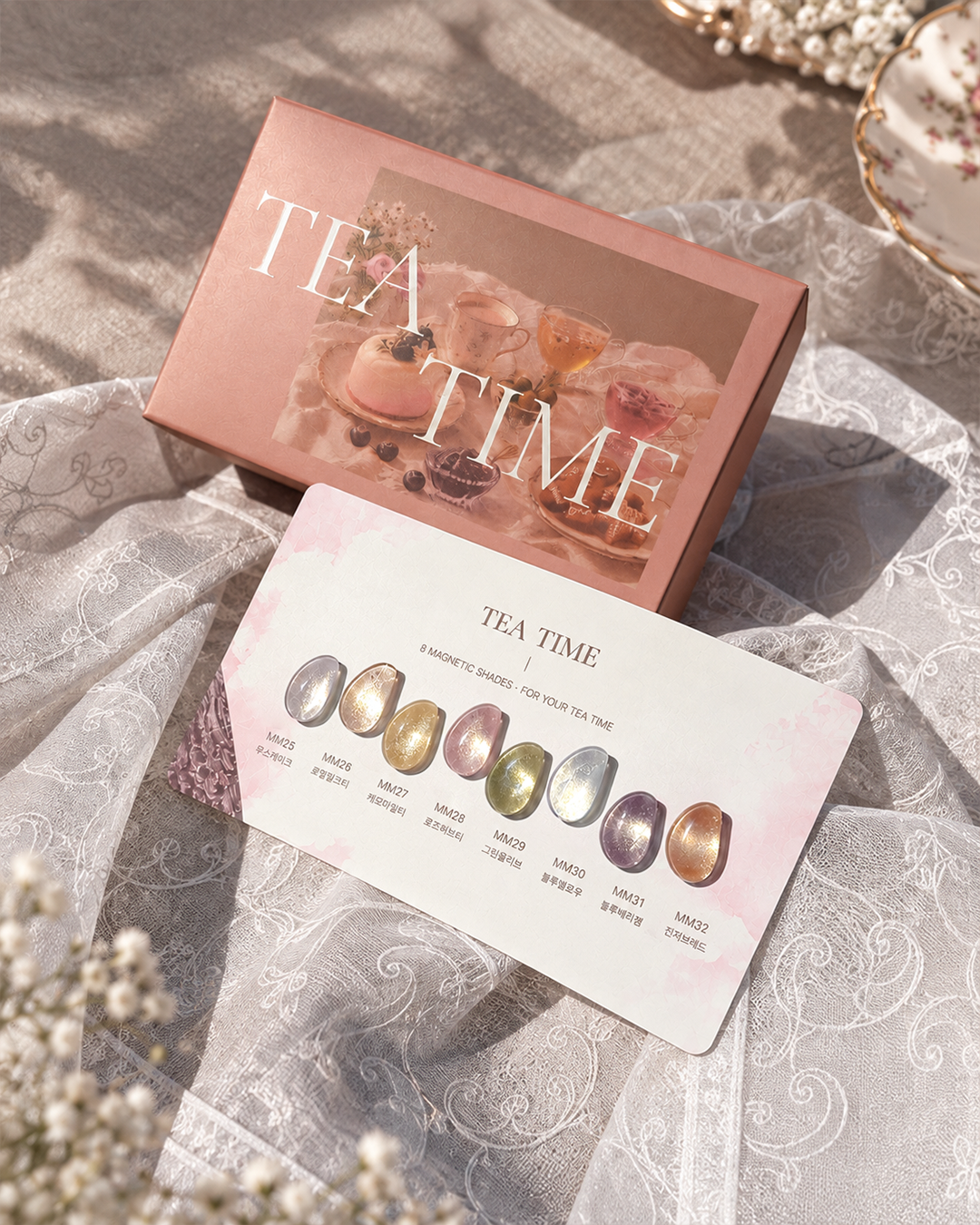 YOGOMAYO Tea Time pink collection box and eight-colour nail swatch card arranged on textured fabric.