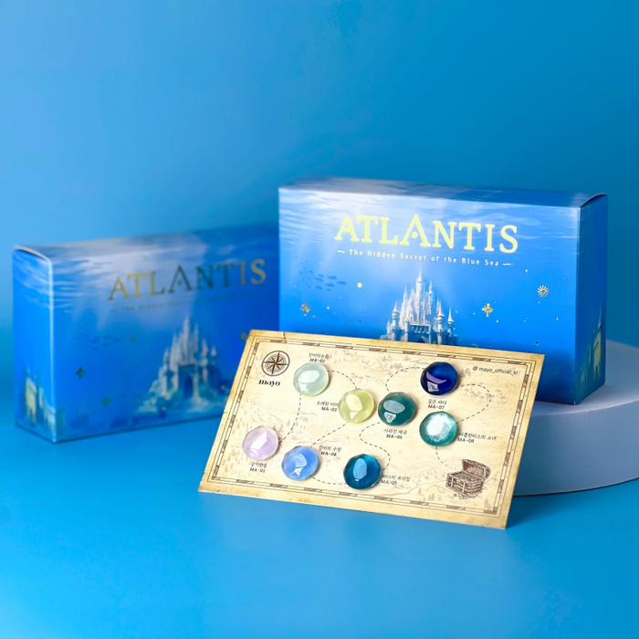 The image showcases a vibrant, blue-toned composition featuring the "ATLANTIS" product collection. Prominently displayed are the Atlantis-branded product packaging, which appears to contain a collection of syrup gels and a silky magnetic cat eye gel, inspired by the deep, ancient sea. The image also includes a color chart and a free cylinder magnet, highlighting the unique color palette and additional features of the Atlantis collection.
