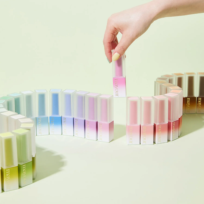 A diverse collection of colorful syrup gel polish bottles arranged in a display, showcasing the vibrant and versatile shades available in the MAYOUR The Collector Season 2 collection. The bottles feature pastel hues and a sleek, modern design that promises an elevated nail art experience for the discerning beauty enthusiast.