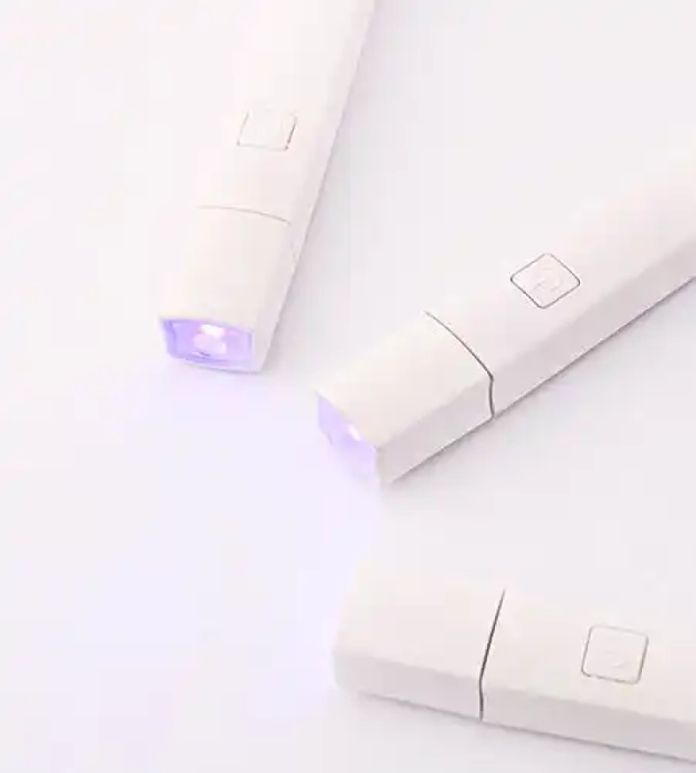 The image shows the MOSTIVE PIN LAMP - SPOT LIGHT, a versatile and hands-free lighting device. The lamp features a stand that can hold a mobile phone, business cards, and art tip cards, making it a second-generation pin lamp. The product offers advantages such as a hands-free stand base, a convex lens for focused curing, and an adjustable pin lamp head angle. This product is designed for easy and convenient use, with a one-minute automatic shut-o