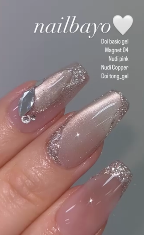 A close-up image of beautifully manicured nails showcasing a shimmering copper gel nail polish color from the NAILBAYO brand. The nails feature a smooth, glossy finish and a subtle sparkle, highlighting the high-quality and self-leveling properties of this Korean nail art product. The image effectively showcases the Nudi Copper gel polish, a versatile base color that can be used for a variety of nail art designs by professionals and beginners ali