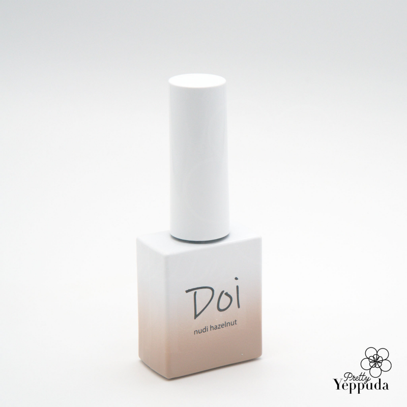 A close-up image of a white and beige bottle labeled "Doi nudi hazelnut" by the renowned Korean nail artist brand NAILBAYO. The bottle showcases the Doi syrup gel base color, known for its excellent self-leveling properties and ease of application for both professionals and beginners in the world of nail art and design.