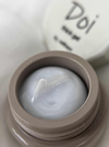 Close-up of Nailbayo DOI Thick Gel container, showcasing the product's luxurious texture and high-quality appearance. The gel's smooth, creamy consistency is visible in the open jar, with the brand name "Doi" prominently displayed on the lid, highlighting its Korean nail art heritage and professional-grade formula.