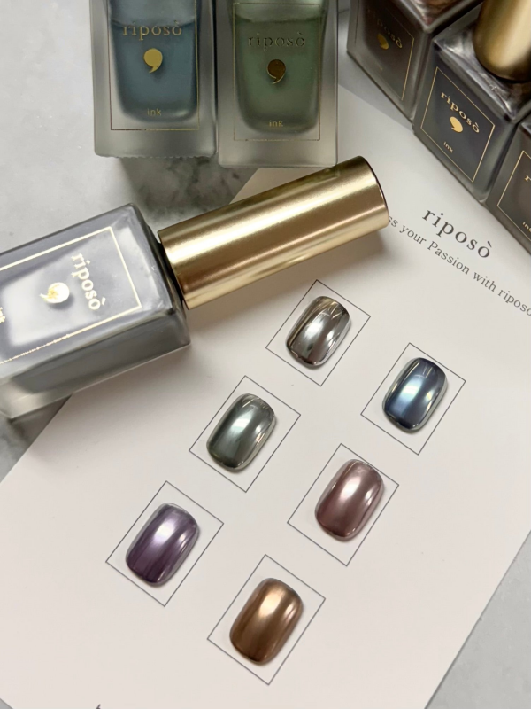 Six individual muted ink bottles from the Riposo Mute Ink Collection, showcasing a range of earthy, metallic hues. The image highlights the elegant packaging and design of this premium Riposo cosmetic brand, featuring a gold-accented bottle and a display of the diverse ink shades available in the set.