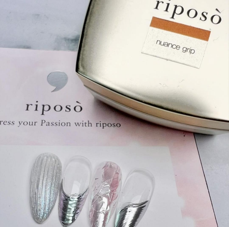 A sleek, minimalist bottle of RIPOSO Nuance Grip Gel sits atop a product brochure, showcasing the brand's dedication to high-quality nail care products that help users express their passion through beautifully nuanced nails. The gel's volume and cure time are clearly displayed, highlighting its functionality and ease of use.