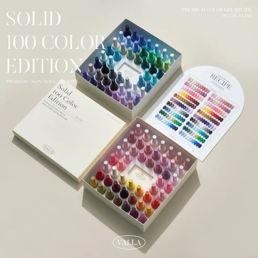 A vibrant, comprehensive collection of 100 solid gel polishes from the VALLA brand, showcasing a diverse array of vivid and saturated colors. The image depicts the product's premium packaging, including a color swatch chart to assist in selecting the perfect shade for a smooth, non-wipe application and long-lasting, one-coat coverage.