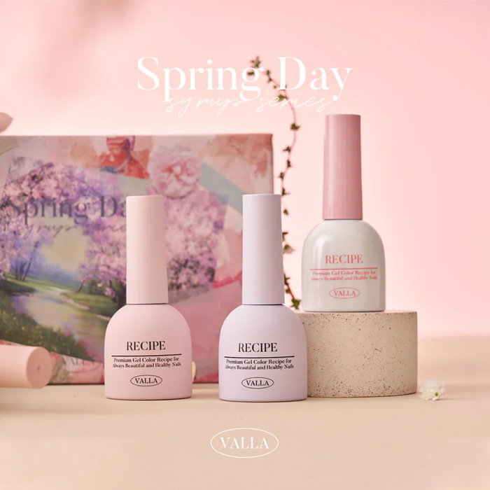 Elegant spring-themed display showcasing the VALLA Spring Day Collection, featuring a variety of pastel-colored gel nail polishes and a glitter gel, set against a soft, floral backdrop. The vibrant and warm colors evoke the feeling of the new spring season.